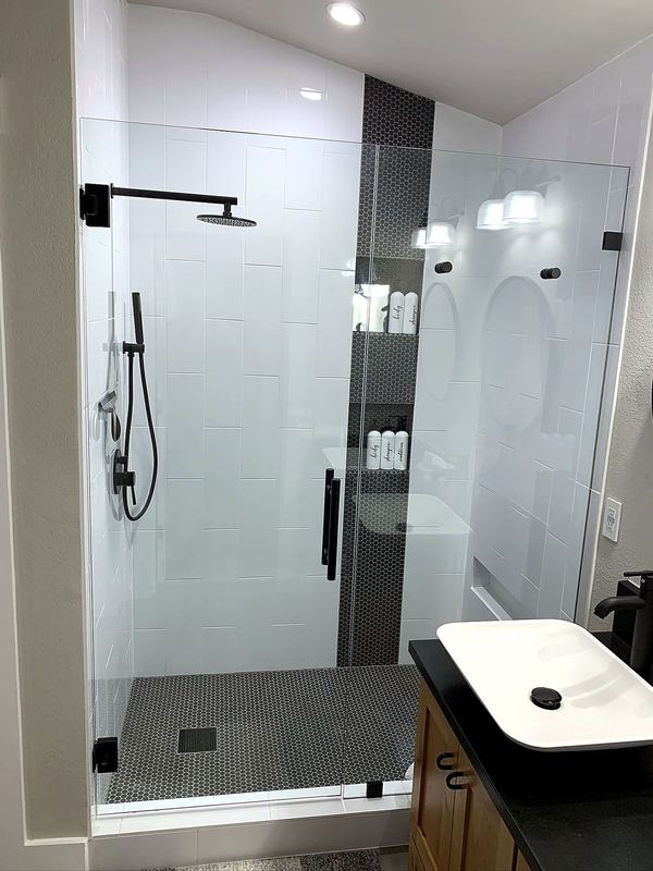 Inline frameless shower door and fixed glass panel by Shower Enclosures by George